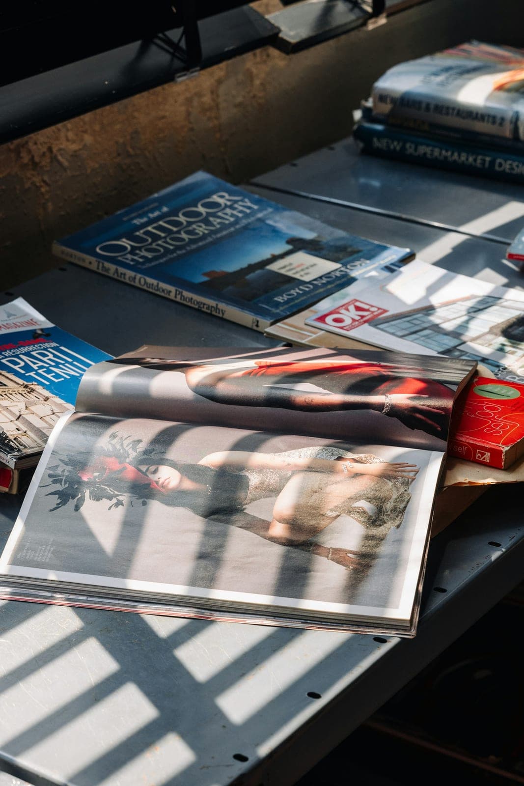 Sunlight casting striped shadows across magazines on a table