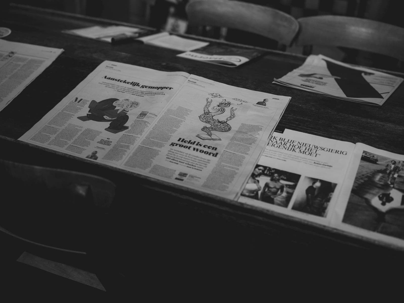Newspapers and magazines laid out on a wooden table