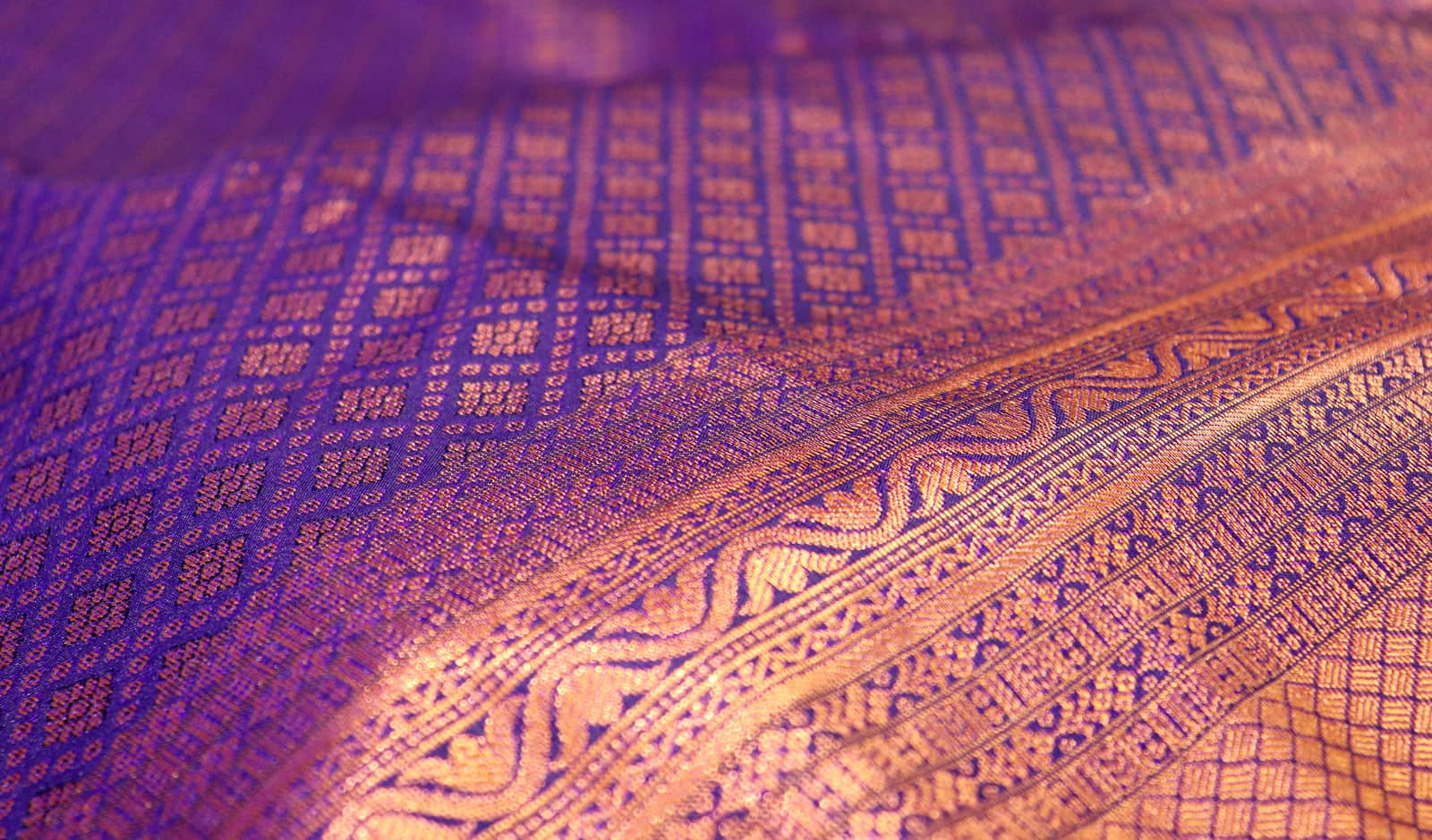 Zari woven into purple silk: a gold border and a field of small motifs