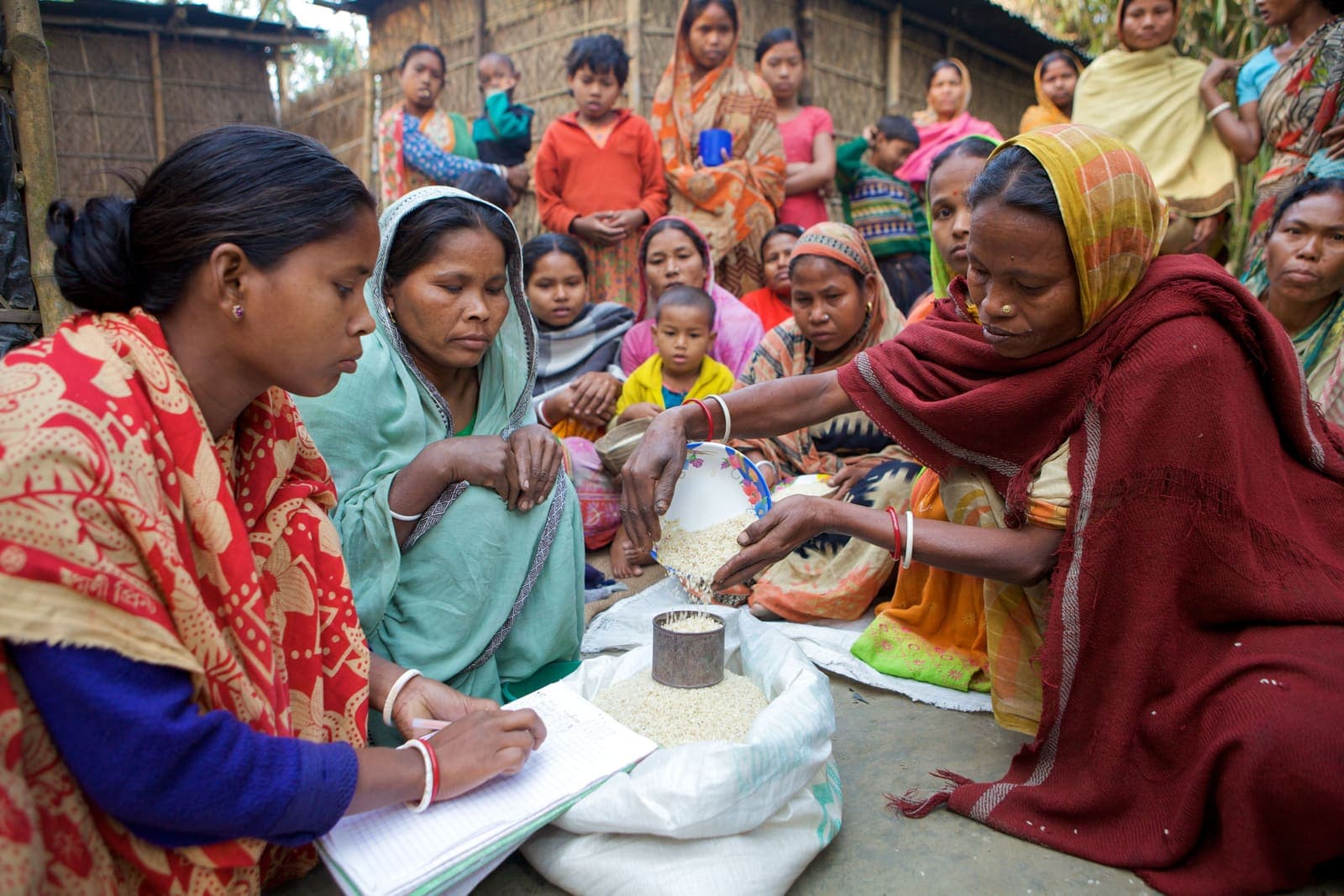 Village women in saris seated together at an outdoor meeting