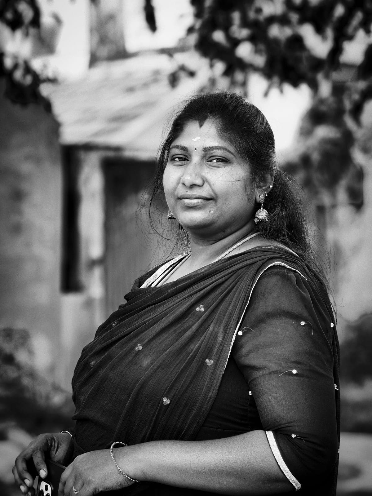 Black-and-white portrait of a woman in a sari, looking at the camera