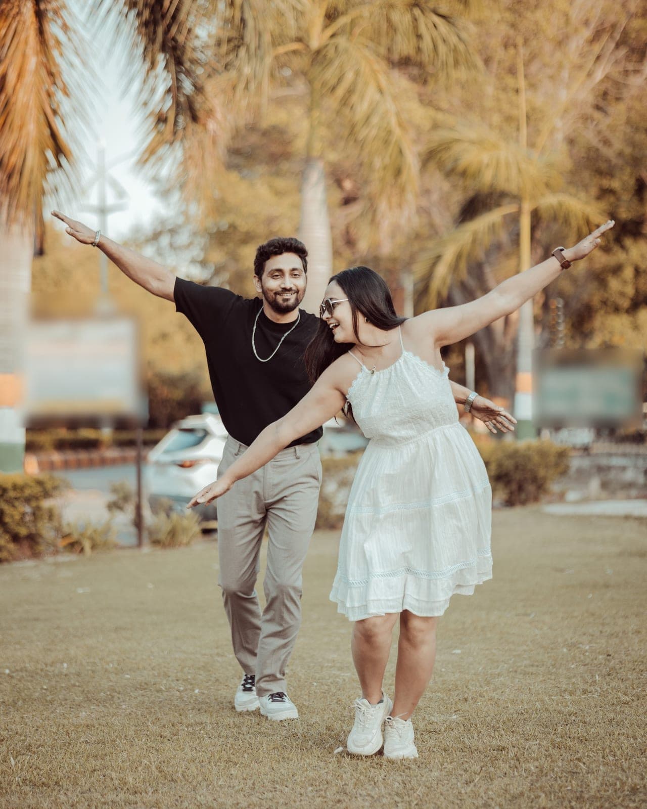 Arjun and Tanvi dance on a garden path, arms flung wide, laughing