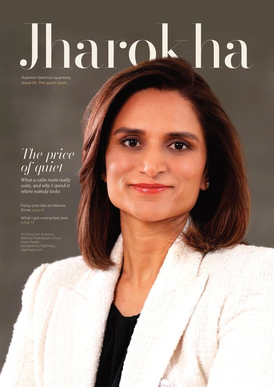Jharokha cover: a close, warm portrait of Rukmini Sethna in an ivory tweed jacket, her head in front of the thin serif masthead Jharokha, lead line The price of quiet